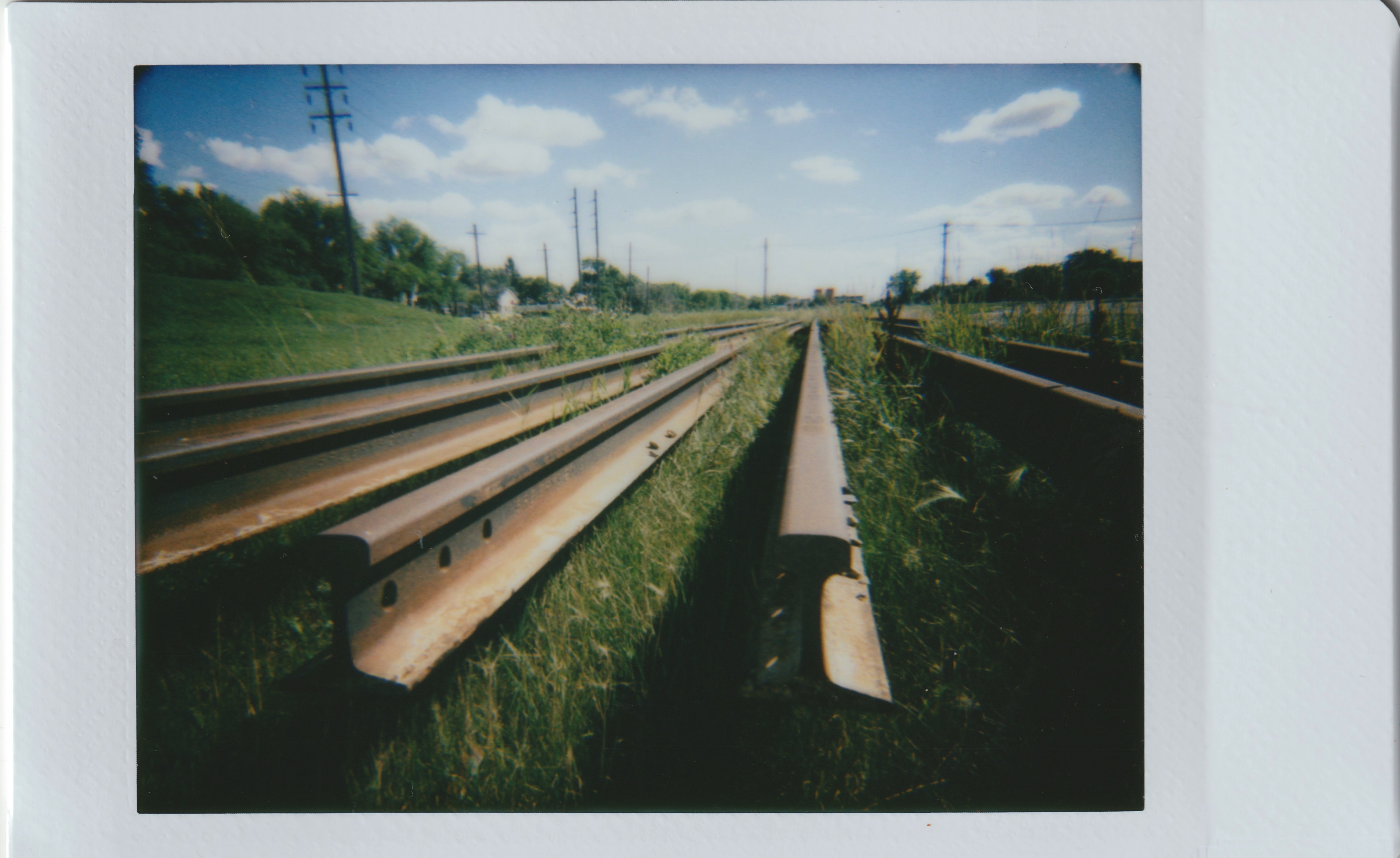 rusty railroad rails sitting in the grass