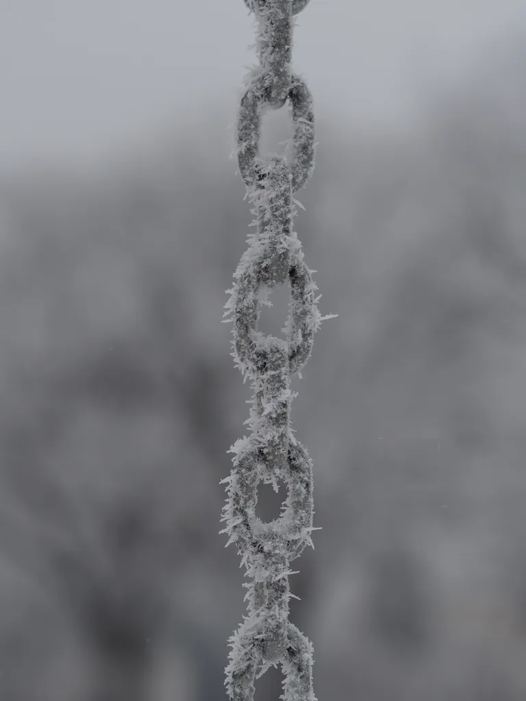 frost on the chain of a swingset