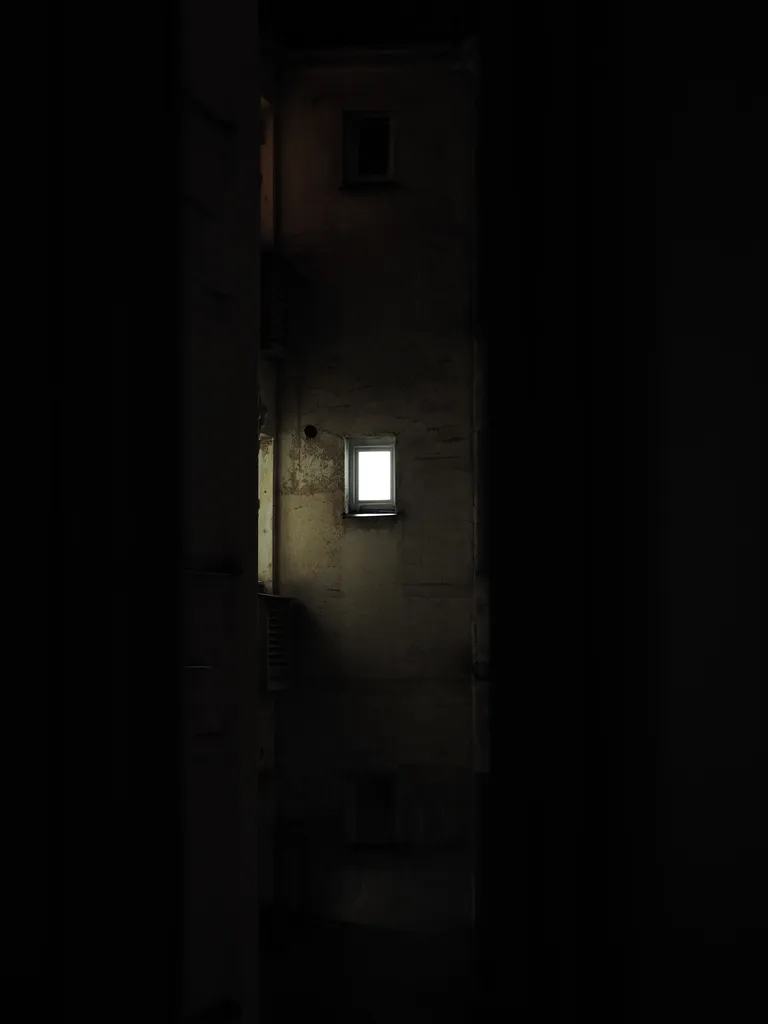a lit window in a hotel room at night