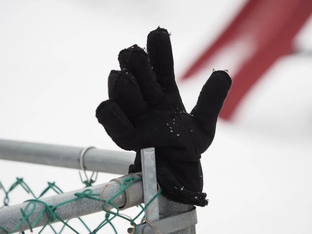 a black glove on the end of a fence