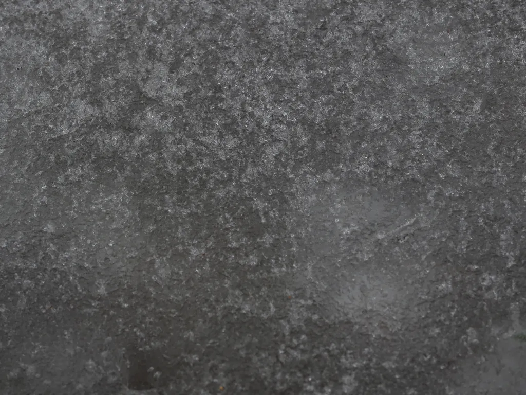 the uneven surface of a frozen puddle
