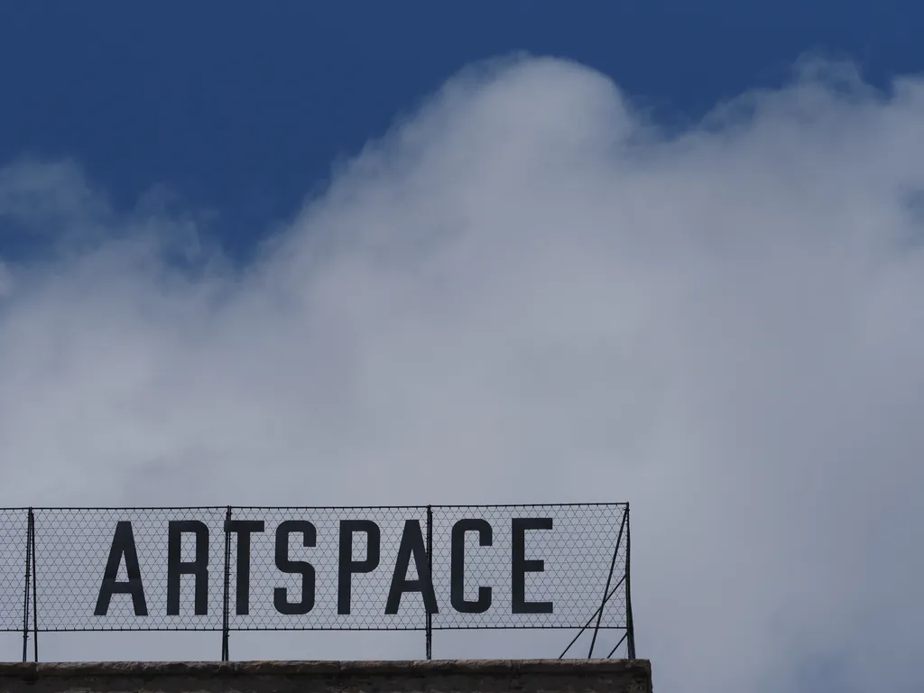 a sign on top of a building: artspace