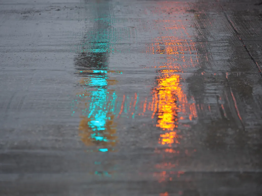 traffic lights reflecting off wet cement