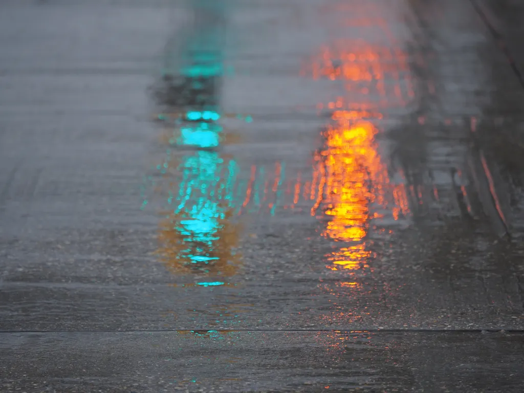 traffic lights reflecting off wet cement