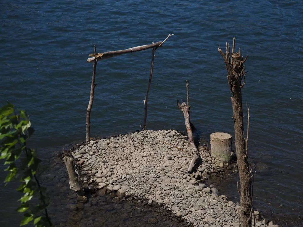 a wooden structure built on a stone path on a river
