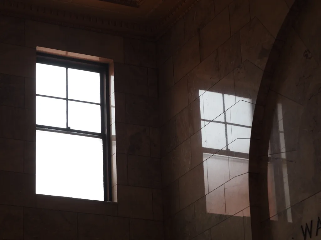 a window reflected in a marble wall