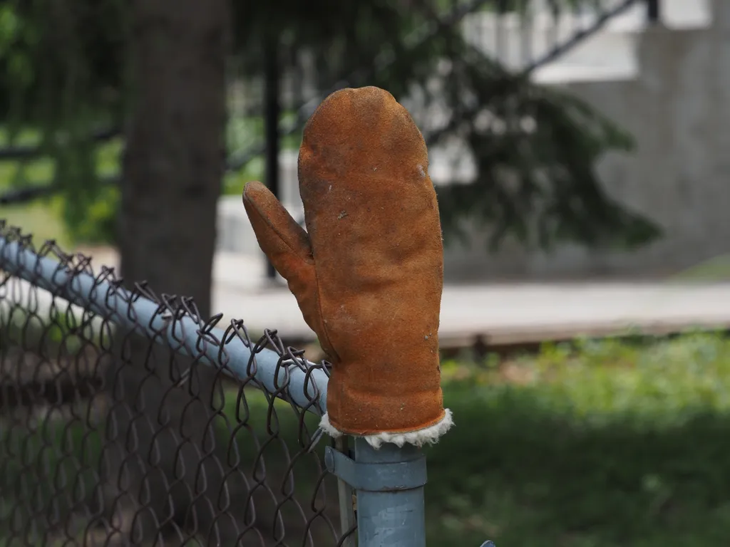 a mitten on a fence post