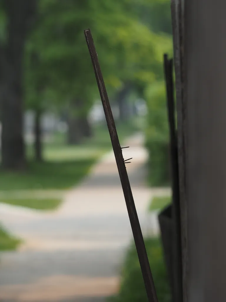 a fence with a loose board dangling