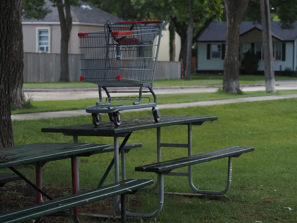 a shopping cart left on a picnic bench
