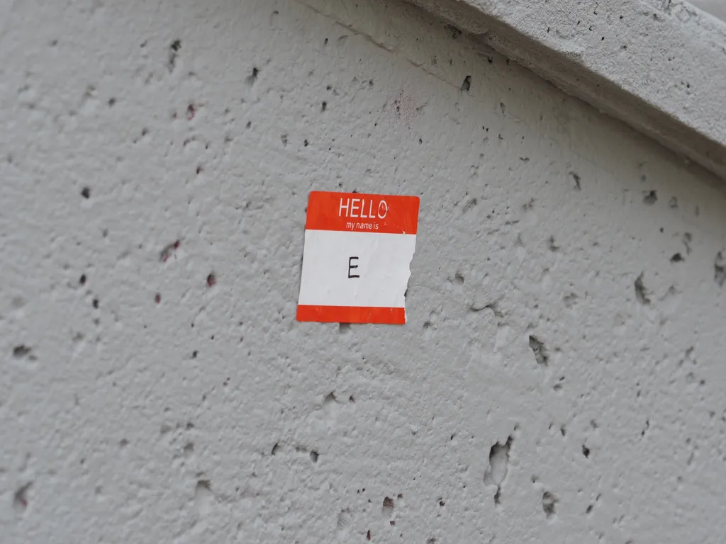 a hello my name is sticker on a wall with the name 'E'