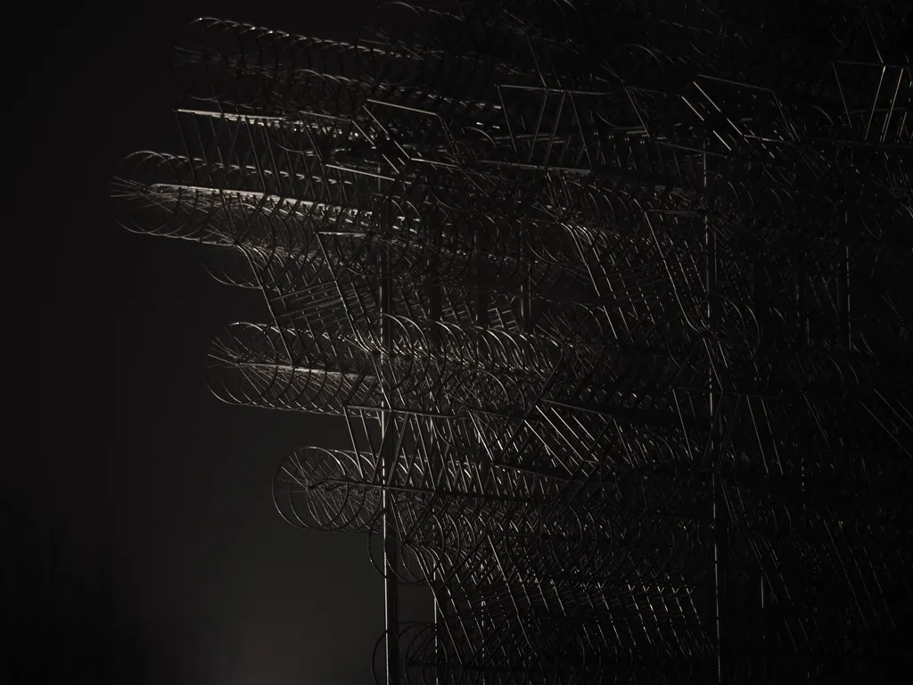 a sculpture made of bicycles on a foggy night